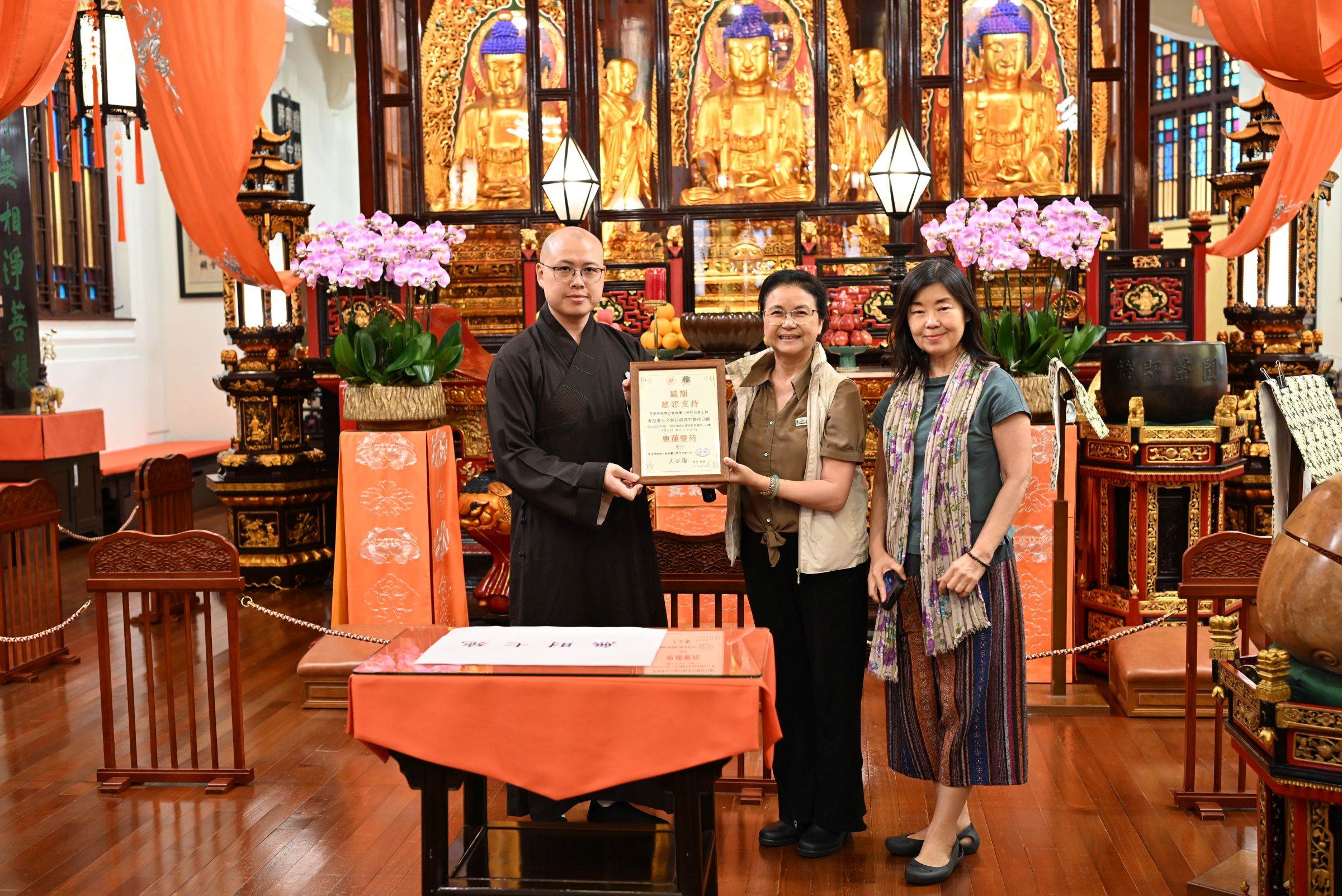 果如法師代表東蓮覺苑，接受佛化德育及價值教育顧問黃鳳鳴女士（中）和梁鳳燕女士（右一）致送的感謝狀。