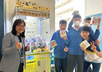 馬寶紅校長（左）派發專屬代幣，讓學生玩校內夾公仔機，夾「STEAM吉祥物」盲盒公仔。